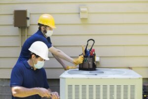 two-technicians-standing-by-central-air-conditioner-working-on-it