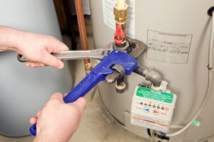 hands-holding-wrench-on-gas-line-on-water-heater