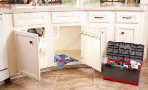 kitchen-cabinets-open-with-plumbing-tools-laid-out